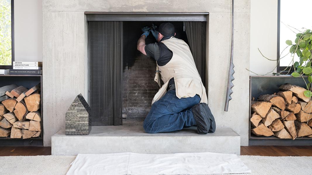 Dowbuilt service superintendent maintaining a fireplace inside high-end residence